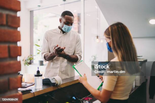 Businessman Disinfects His Hands At Hotel Reception Covid19 Pandemic Stock Photo - Download Image Now