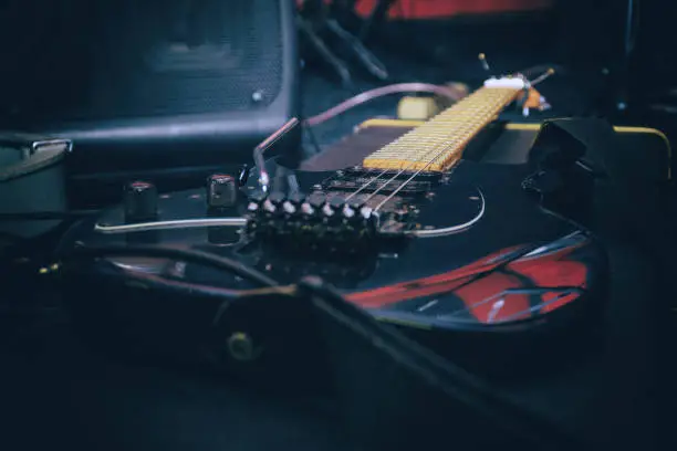 Photo of Black electric guitar with tremolo on a hard case
