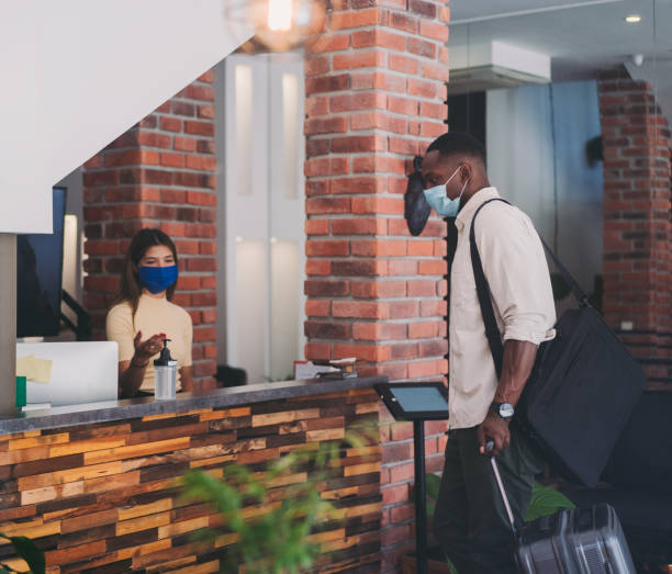 istock Receptionist asks a tourist to disinfect his hands at the hotel 1304909165