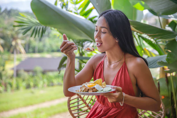 istock Indonesian Woman Eating Fried Rice for Breakfast 1304910251