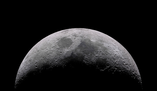 Luna creciente encerada con un fondo de estrellas del cielo nocturno. Increíble vista de la diminuta superficie lunar iluminada por el sol y el lado oscuro de la luna. Línea delgada dramática cortada en el nighsky estrellado photo