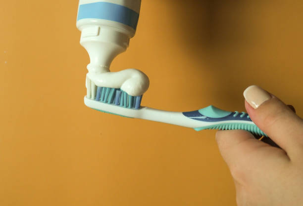 istock Woman squeezes toothpaste on a brush 1304912429