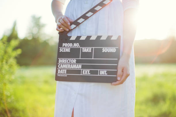 istock Woman holds clapper board at sunset 1304913476