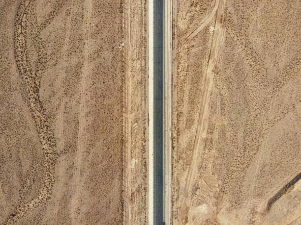 vista aérea da rodovia no deserto - arid climate asphalt barren blue - fotografias e filmes do acervo