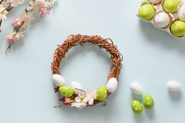 istock Makind Easter wreath of colorful pastel eggs on blue. 1304918156