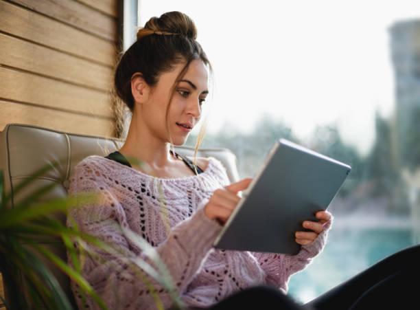 istock Young Woman Using Digital Tablet At Home Nearby Window 1304918641