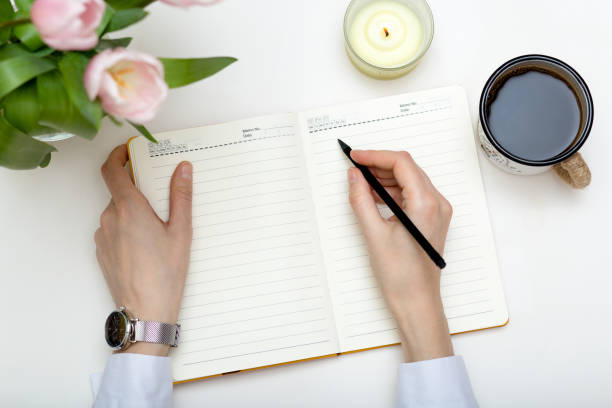 istock Woman hands with planner on white, cozy workplace. 1304923285