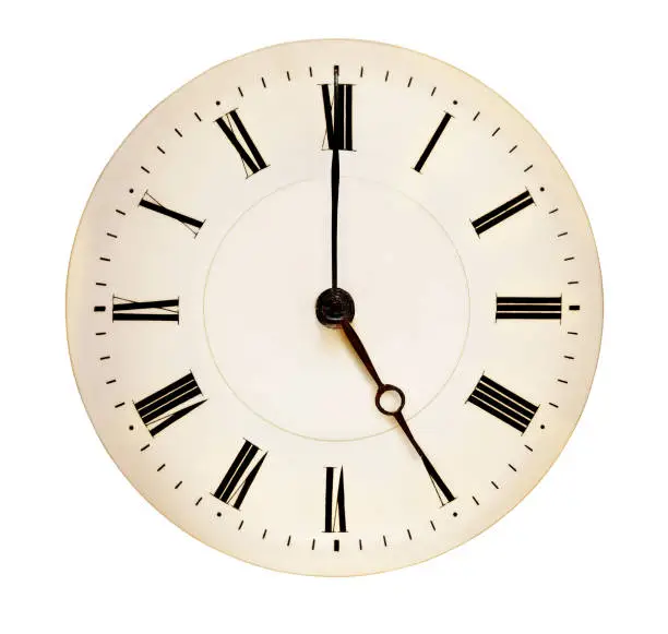 Antique clock face pointing at fiveo'clock isolated against white background. Tea time concept