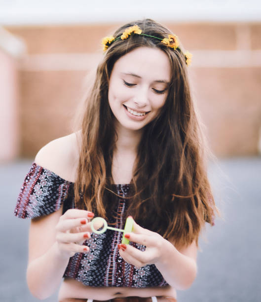 istock Beautiful young woman playing with a child's bubble-blower 1304927681