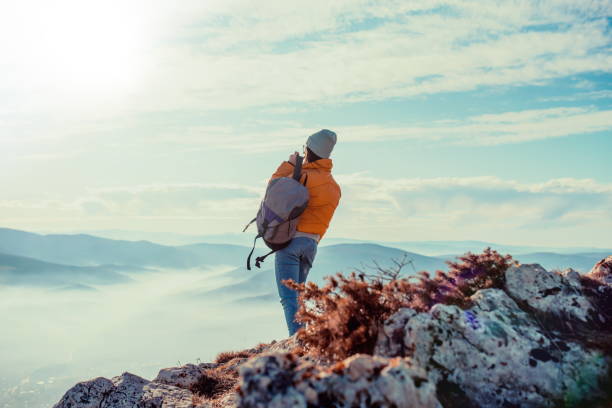istock Cheering woman backpacker enjoy the view on sunrise mountain top cliff edge 1304927733
