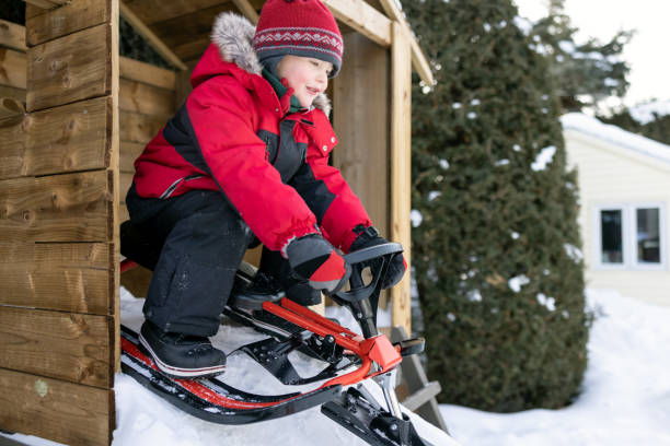 маленький мальчик санях на снегу на открытом воздухе в зимний период - little boys sled clothing slide стоковые фото и изображения
