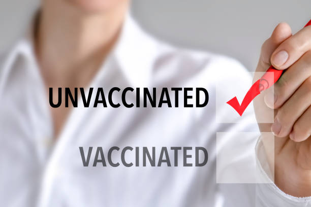 Woman choosing to be unvaccinated Woman making a check mark to be unvaccinated on the white visual board. anti vaccination stock pictures, royalty-free photos & images