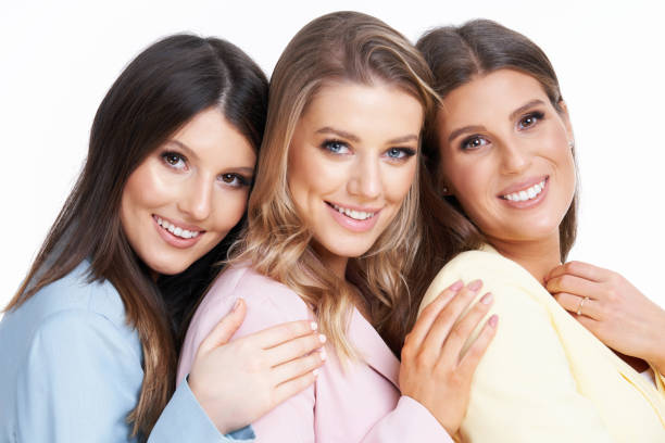 istock Three women in pastel suits posing over white background 1304932947