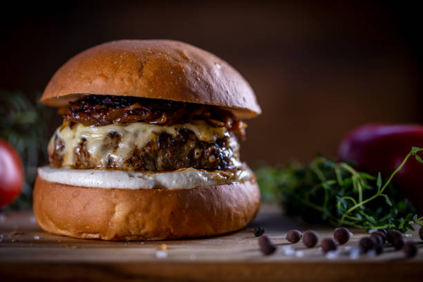 istock Craft beef burger with cheese, caramelized onion and sauce on wooden background 1304932999