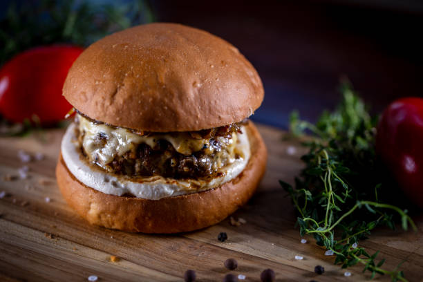 istock Craft beef burger with cheese, caramelized onion and sauce on wooden background 1304933013