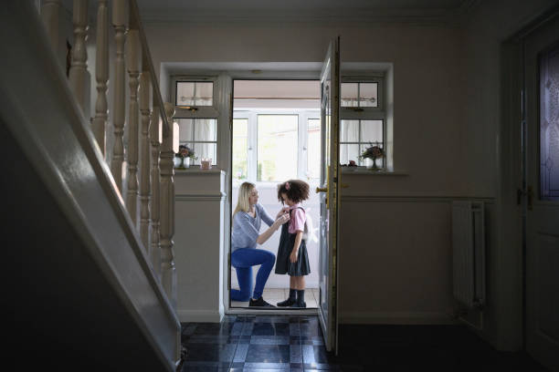 istock Caucasian mother helping mixed race daughter with backpack 1304935103