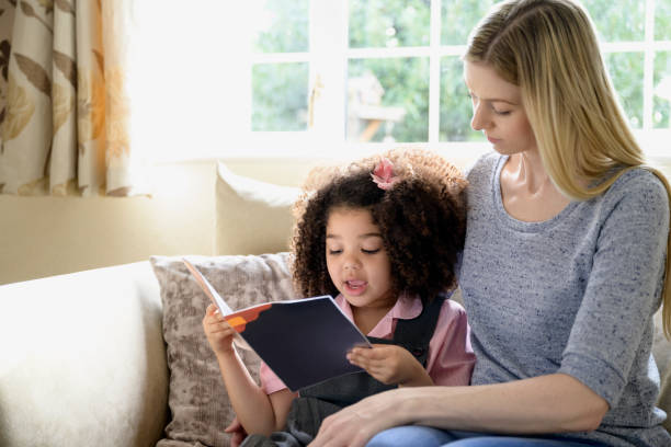 istock Mixed race girl practicing reading at home with her mother 1304935116