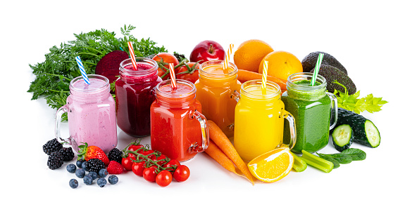 Collection of healthy fresh organic fruits and vegetables smoothies in Mason jars arranged in a row on white background. Fruits and vegetables included in the composition are strawberries, blueberries, beetroot, tomatoes, carrots, oranges, celery, cucumber, avocado, red apple and spinach. High resolution 42Mp studio digital capture taken with Sony A7rII and Sony FE 90mm f2.8 macro G OSS lens