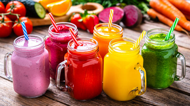 istock Healthy rainbow colored fruits and vegetables smoothies on rustic wooden table 1304936741