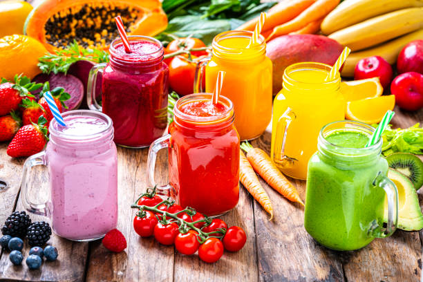 istock Healthy rainbow colored fruits and vegetables smoothies on rustic wooden table 1304936748