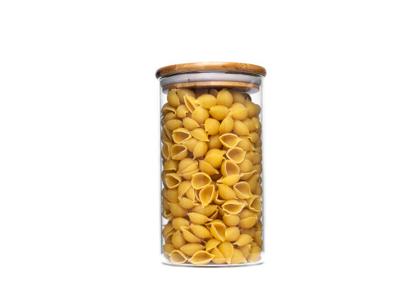istock Conchiglie rigate pasta in glass jar isolated on white background 1304938213