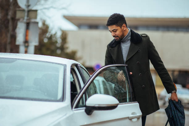 homme d’affaires afro obtenant dans sa voiture - entrer photos et images de collection