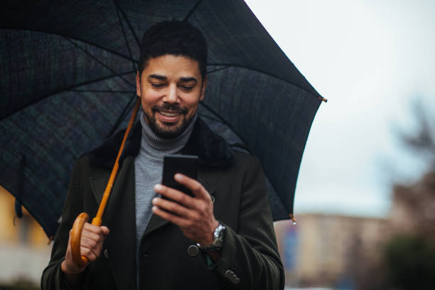 istock African american male using phone on a rainy day 1304942622