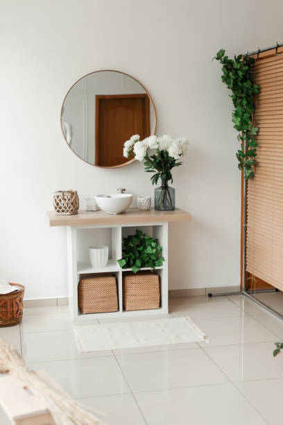istock beautiful bathroom interior with mirror and flowers 1304943439