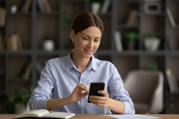 istock Smiling woman look at cellphone screen browsing internet 1304943777