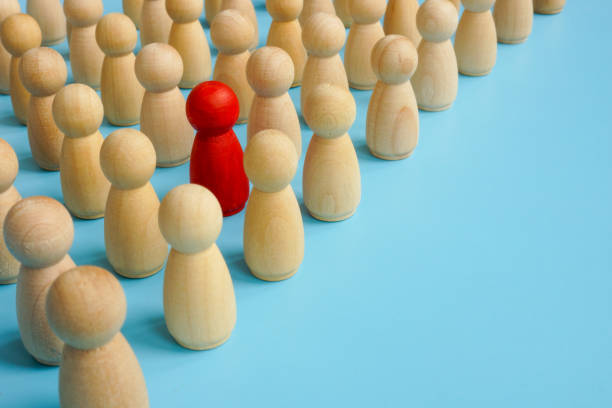 istock Be different in the crowd. Unique red figure with wooden ones. 1304944879