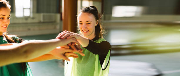 istock Banner- long format, young sport people putting their hands together. Stack of hands. Unity and teamwork concept. Happy women toghether 1304944936