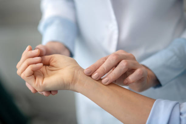 istock Female doctors hands gently palpating patients forearm 1304946851