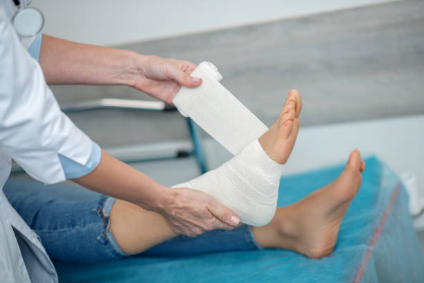 istock Doctors hands bandaging leg of lying patient 1304947056