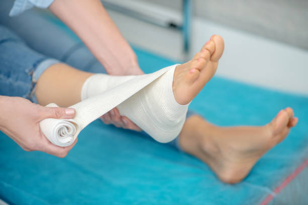 istock Hands applying elastic bandage to injured ankle 1304947116