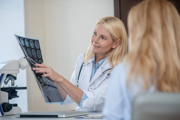 istock Doctor deciphering MRT scan showing it to patient 1304947193