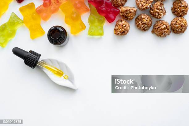Gummy Bears Cannabis Cookies And Cbd Oil Dropper In White Backdrop Stock Photo - Download Image Now