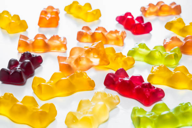 Gummy bear candy in white backdrop. THD or cbd cannabis sweets in form of gelatine gummi bears, calming edible food supplements gummy candy photos stock pictures, royalty-free photos & images
