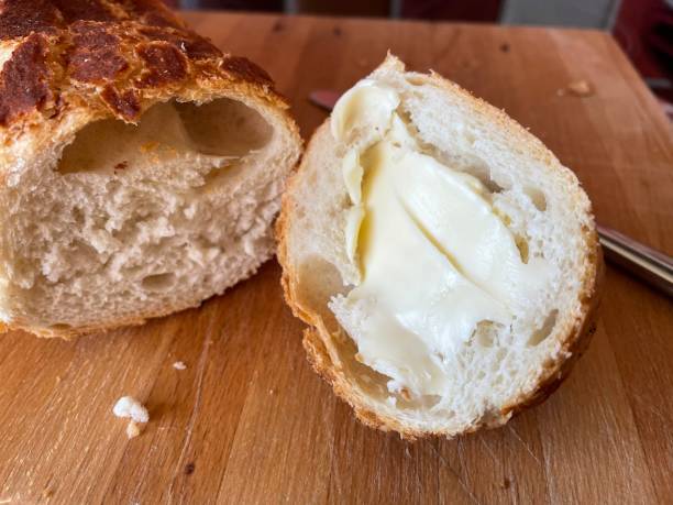 istock Cutting French stick bread with butter 1304950793
