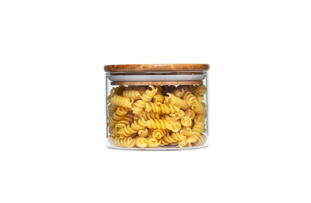 istock Fusilli pasta in a glass jar isolated on a white background 1304951533