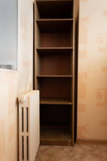 istock A close-up view from the inside of a small kitchen: a rusty central heating radiator and storage shelves. Preparation for repair work. 1304952725