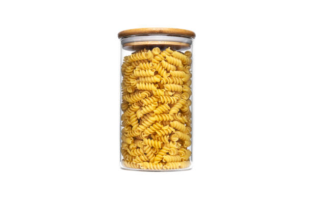 istock Fusilli pasta in a glass jar isolated on a white background 1304952744