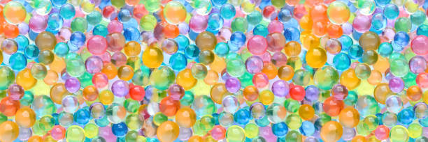 istock Abstract multicolored wide panoramic background with hydrogel beads texture. Water absorbent balls 1304954248