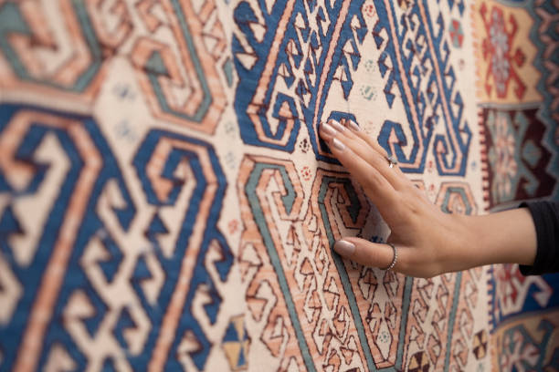 jeune femme touchant le tapis turc traditionnel. - carpet rug persian rug persian culture photos et images de collection