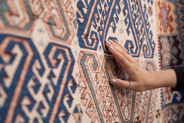 giovane donna che tocca il tradizionale tappeto turco. - carpet rug persian rug persian culture foto e immagini stock