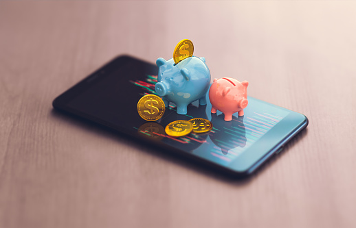 trading in financial markets - smartphone with charts and piggy bank