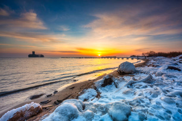 日没時のバビー・ドイのバルト海の凍ったビーチ、グディニア - beach sunrise waterbreak sea ストックフォトと画像