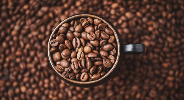 istock Top view on coffee cup full with coffee beans. 1304954643