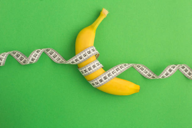 istock Closeup on banana and white centimeter on the green background 1304954833