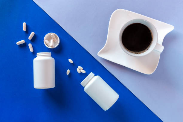 istock Two white bottle, pills, coffee cup on blue background. Concept Insomnia, full moon time, sleep problems, soporific. Mockup, Top view, Flat lay, Copy space. 1304957566