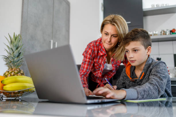istock Mother and son following online classes via laptop 1304957768